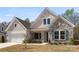 Charming home featuring stone accents, craftsman style details, well-manicured landscaping, and a two car garage at 7500 Happy Hollow Dr, Mint Hill, NC 28227