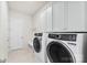 Efficient laundry room with white cabinets, tile floor, and modern washer and dryer appliances at 7500 Happy Hollow Dr, Mint Hill, NC 28227
