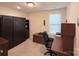 This bedroom features a Murphy bed and a built-in desk with wooden cabinets at 7581 Short Putt Ct, Charlotte, NC 28215