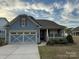 Charming blue single-story home featuring a covered porch and attached two car garage at 7581 Short Putt Ct, Charlotte, NC 28215