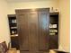 This dark wood Murphy bed features built-in shelves, offering storage and style at 7581 Short Putt Ct, Charlotte, NC 28215