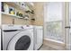 Bright laundry room with modern appliances, wire shelving, and a window for natural light at 7844 Village Harbor Dr, Cornelius, NC 28031