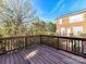 Expansive wooden back deck with views of a brick home and wooded area at 7854 Springs Village Ln, Charlotte, NC 28226