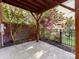 Covered backyard patio with greenery, a brick wall, and black metal fence at 7854 Springs Village Ln, Charlotte, NC 28226