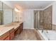 Bathroom featuring double vanity, tub, and tiled shower at 7854 Springs Village Ln, Charlotte, NC 28226