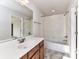 Bathroom with shower over tub, white tile surround, and a modern vanity with a large mirror at 7854 Springs Village Ln, Charlotte, NC 28226
