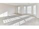 Bright bedroom with neutral carpet, windows, and custom shutters at 7854 Springs Village Ln, Charlotte, NC 28226