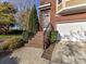Front entrance featuring brick steps with iron railings and an attached two-car garage at 7854 Springs Village Ln, Charlotte, NC 28226