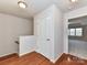 Upstairs hallway with hardwood floors leads to a bedroom, offering ample natural light and closet space at 7854 Springs Village Ln, Charlotte, NC 28226