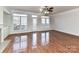 Bright living room featuring hardwood floors and windows with plantation shutters at 7854 Springs Village Ln, Charlotte, NC 28226
