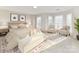 Sun-filled bedroom with neutral decor, a sitting area, and large windows at 7854 Springs Village Ln, Charlotte, NC 28226