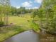 Scenic pasture view with horses grazing, a charming creek, and a clear sky backdrop at 807 And 809 Sparrow Springs Rd, Kings Mountain, NC 28086
