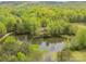 Aerial view showcases a tranquil pond surrounded by lush, mature trees providing peaceful seclusion at 807 And 809 Sparrow Springs Rd, Kings Mountain, NC 28086