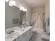 Bright bathroom featuring a double sink vanity, floral shower curtain, and neutral tile flooring at 878 Treasure Ct, Fort Mill, SC 29708