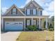 Charming two-story home featuring a welcoming front porch and attached two car garage at 878 Treasure Ct, Fort Mill, SC 29708
