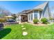Spacious backyard with covered patio, seating area, barbecue grill, and lush green grass at 9727 Glenburn Ln, Charlotte, NC 28278
