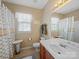 Well-lit bathroom with a pedestal sink, toilet, and a shower with a patterned curtain at 9727 Glenburn Ln, Charlotte, NC 28278