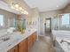 Bright bathroom featuring double sinks, a soaking tub, and separate glass-enclosed shower at 9727 Glenburn Ln, Charlotte, NC 28278
