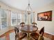 A dining area features a round table with seating near a bay window, complemented by a decorative painting at 9727 Glenburn Ln, Charlotte, NC 28278
