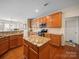 Open kitchen with a central island, granite counters, stainless appliances, and maple cabinets at 9727 Glenburn Ln, Charlotte, NC 28278