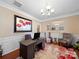 Home office with dark wood desk, modern chairs, and a decorative rug under a modern chandelier at 9727 Glenburn Ln, Charlotte, NC 28278