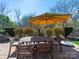 Outdoor patio with wooden table, chairs, and a large sun umbrella at 9727 Glenburn Ln, Charlotte, NC 28278