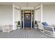 Elegant front door with decorative glass, potted plants, and a charming wicker rocking chair at 101 E Main St, Cleveland, NC 27013