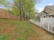 A lovely backyard is bordered by a white picket fence on one side and a wood fence on the other at 1018 Davant Ln, Charlotte, NC 28209