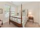 Cozy bedroom with a four-poster bed, side table and lamp, and a sunlit window at 1018 Davant Ln, Charlotte, NC 28209