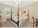 Sunlit bedroom features a four-poster bed, side table and lamp, and a window at 1018 Davant Ln, Charlotte, NC 28209