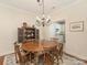 Elegant dining room with a wooden table, ornate chandelier, and a glimpse into the adjacent kitchen at 1018 Davant Ln, Charlotte, NC 28209