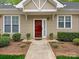 Welcoming entrance with a red front door, surrounded by lush greenery and framed by a paved walkway at 1018 Davant Ln, Charlotte, NC 28209