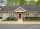 Charming single-story home with a red front door, complemented by manicured landscaping and neutral-colored siding at 1018 Davant Ln, Charlotte, NC 28209