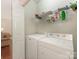 A bright laundry room features a washer, a dryer and white shelves at 1018 Davant Ln, Charlotte, NC 28209