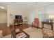 Comfortable living area with a TV, artwork, a patterned chair, and natural light streaming through the window at 1018 Davant Ln, Charlotte, NC 28209