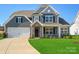 Charming two-story home features a manicured lawn, a two-car garage, and stylish stone accents at 104 Hemlock Cove Ct, Mooresville, NC 28117
