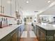 Well-lit kitchen with white and green cabinets, subway tile backsplash, and stainless steel appliances at 104 Hemlock Cove Ct, Mooresville, NC 28117