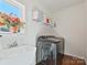Bright laundry room featuring a modern washer, sink and a decorative touch of floral arrangement by the window at 104 Hemlock Cove Ct, Mooresville, NC 28117