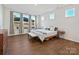 Serene main bedroom with three windows, a bench, and hardwood floors, offering a tranquil retreat at 104 Hemlock Cove Ct, Mooresville, NC 28117