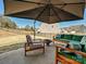 Inviting outdoor patio with comfortable seating, a fire pit, and a large umbrella for shade in the backyard at 104 Hemlock Cove Ct, Mooresville, NC 28117