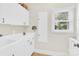Laundry room features white cabinets, a sink, and a window offering natural light at 105 Beach Ln, Mooresville, NC 28117