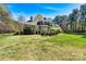 View of the backyard showing the back of the home and a spacious lawn at 107 Bare Foot Ln, Mooresville, NC 28117