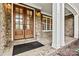 Charming front porch with brick flooring, white columns, and wood framed glass doors at 107 Bare Foot Ln, Mooresville, NC 28117