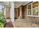 Inviting brick front porch with white columns and wood door at 107 Bare Foot Ln, Mooresville, NC 28117