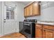 Functional laundry room features modern washer/dryer, sink, wooden cabinets, and an exterior door at 107 Bare Foot Ln, Mooresville, NC 28117