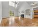 Bright living room featuring hardwood floors, fireplace, built-ins, and french doors to the backyard at 107 Bare Foot Ln, Mooresville, NC 28117
