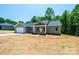 Inviting single-story home featuring a front porch, attached garage, and new construction in a wooded area at 1127 Mckay Rd, Newton, NC 28658