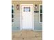 Close-up of a front door with sidelights, an address plaque, and porch lights, inviting entrance at 1127 Mckay Rd, Newton, NC 28658
