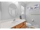 Well-lit bathroom with a modern vanity, round mirror and white tiled walls at 11507 Rabbit Ridge Rd, Charlotte, NC 28270