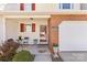 Inviting covered front porch with red door, a bistro set, and manicured plants at 11507 Rabbit Ridge Rd, Charlotte, NC 28270